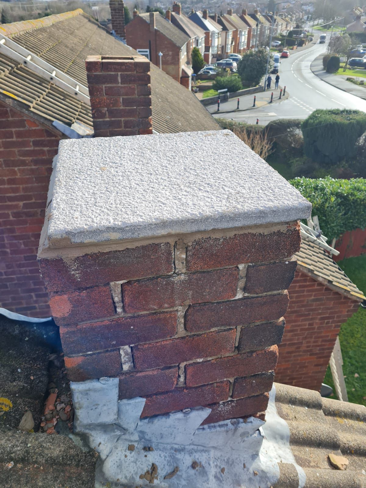 Chimney stack with new concrete cap viewed from rooftop